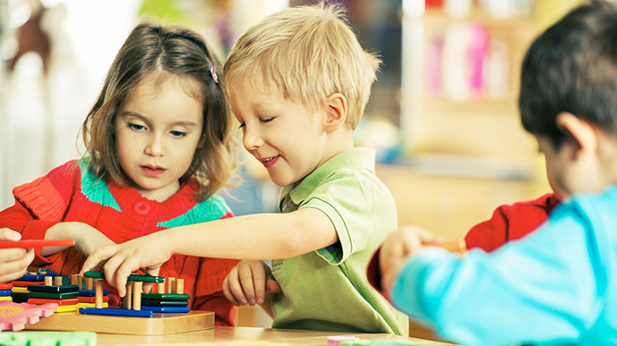 Szene im Kindergarten: Kinder bauen gemeinsam Steckturm.